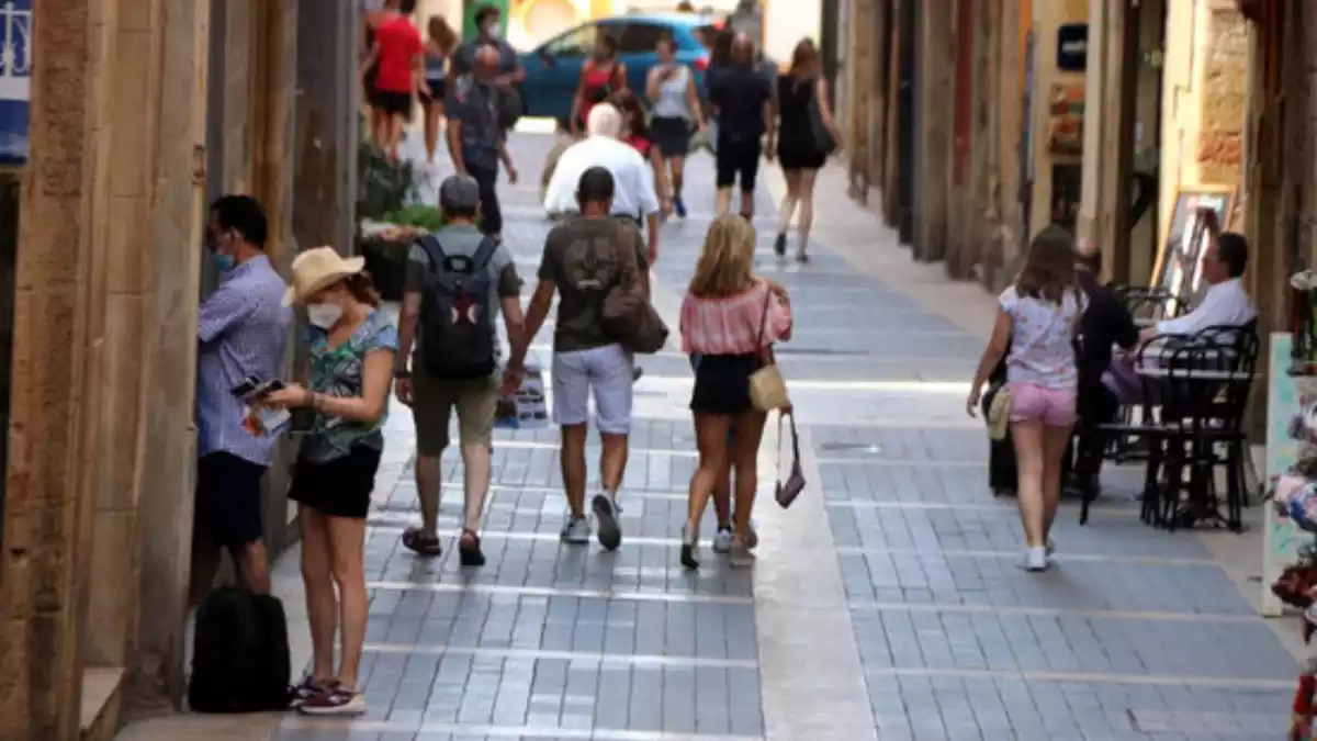 Diverses persones caminant pel Carrer Major de Tarragona, a la Part Alta