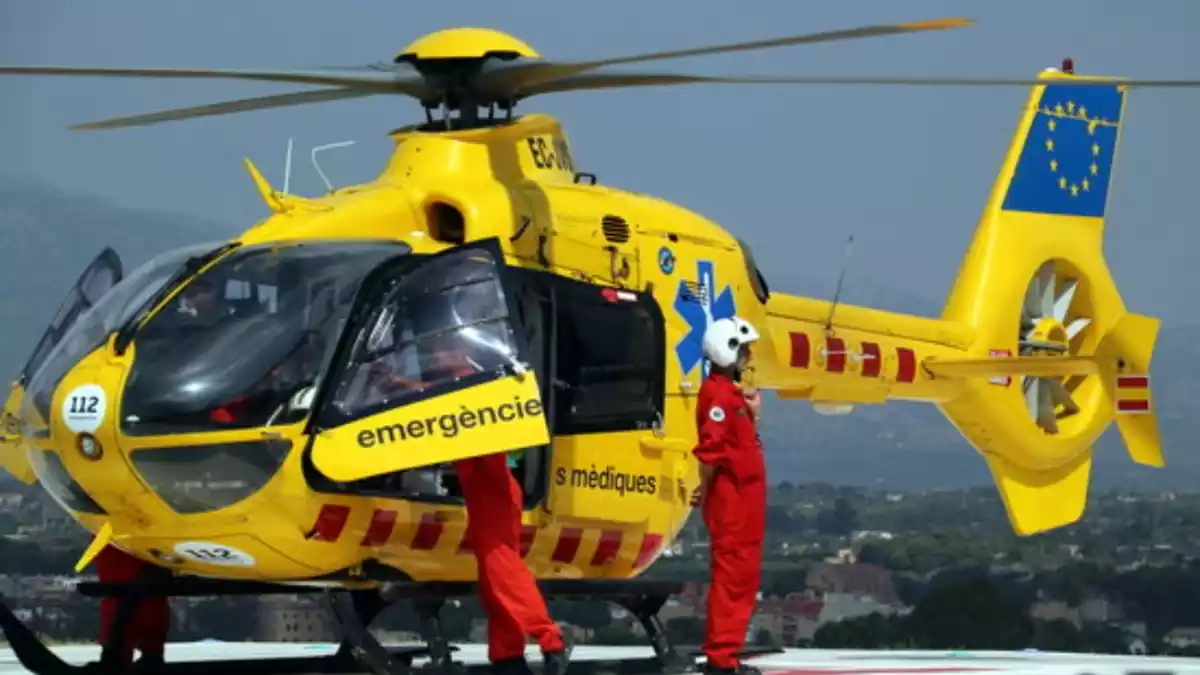 Dos pilots baixant de l'helicòpter del Servei d'Emergències Mèdiques (SEM)