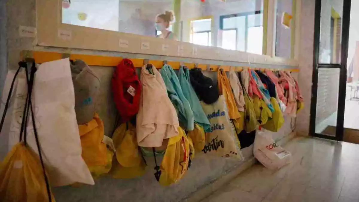 Imatge dels penjadors d'una llar d'infants, amb bosses, jaquetes i bates