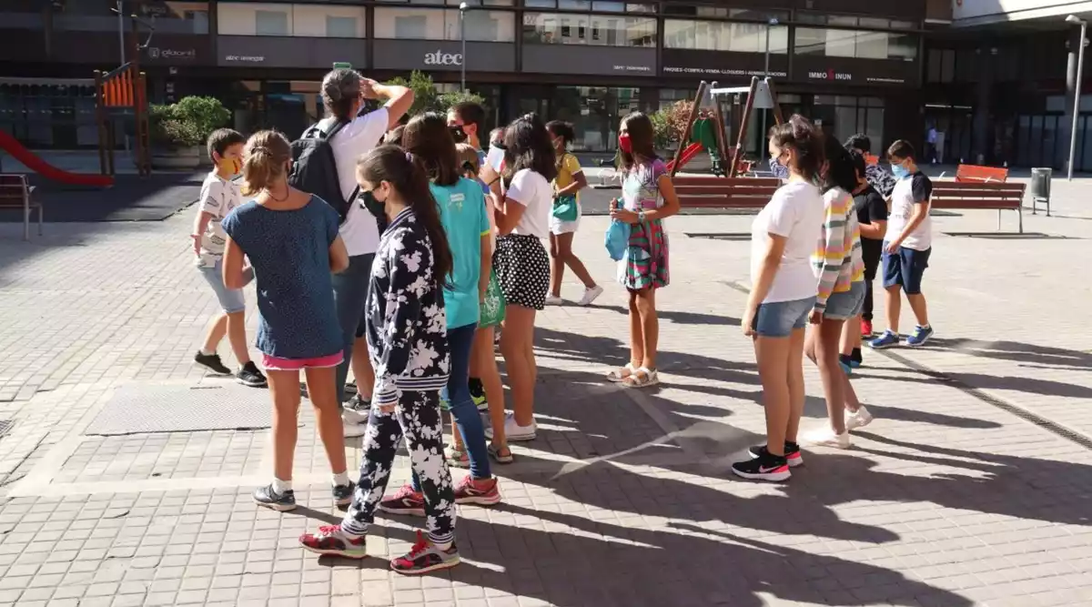 Pla obert d'un grup d'alumnes de l'escola Eiximenis arribant a la plaça de Josep Pla de Girona