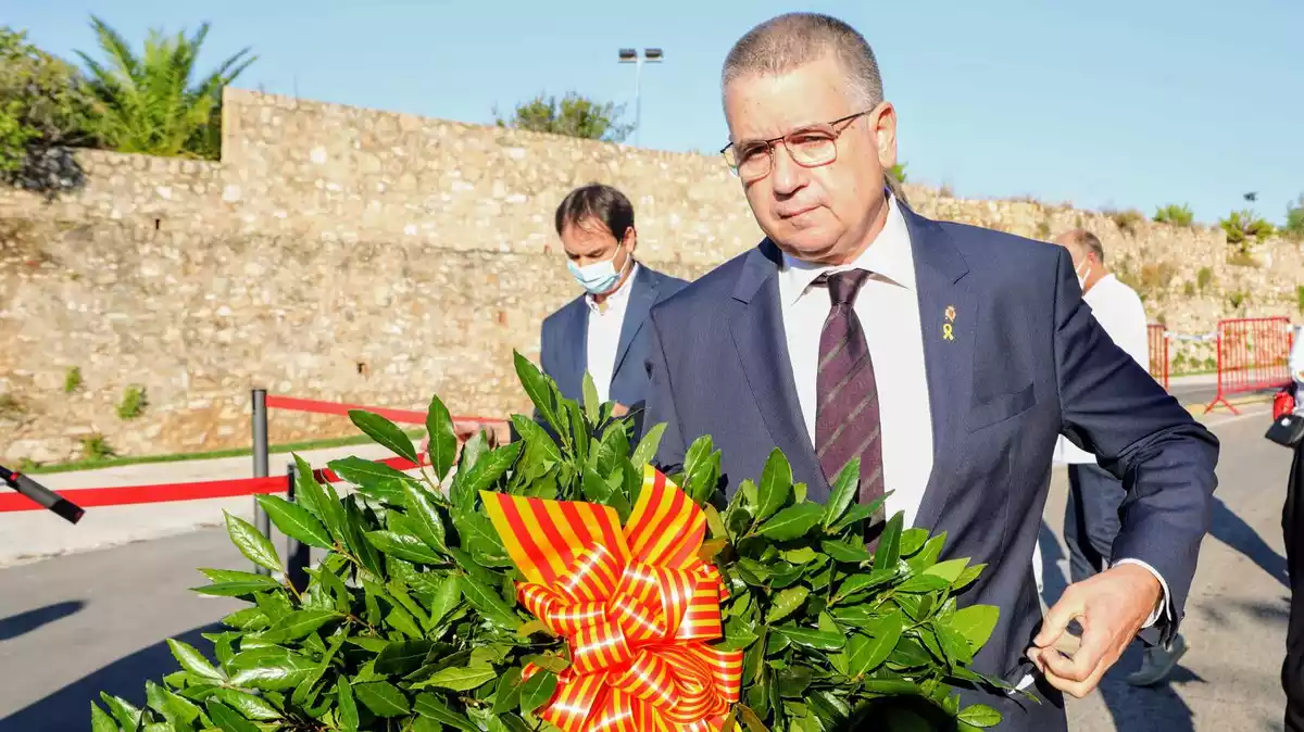 Pla detall de Ricomà, amb les flors abans de fer l'ofrena a Rafel de Casanovas