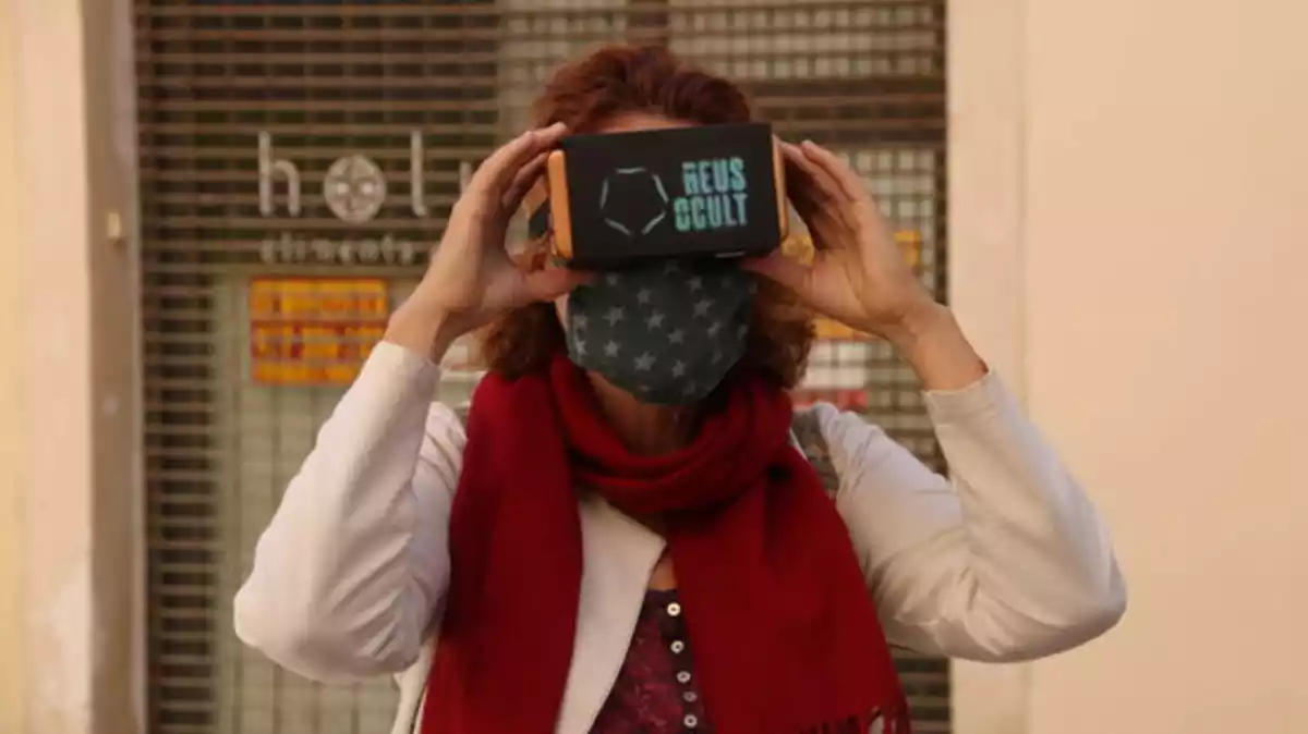 Pla tancat d'una participant utilitzant les ulleres de realitat estereoscòpica en la visita al campanar de la Prioral de Sant Pere, activitat organitzada per Reus Ocult