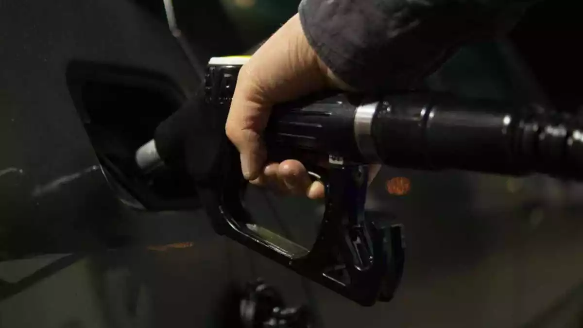 Una persona posa combustible al seu cotxe