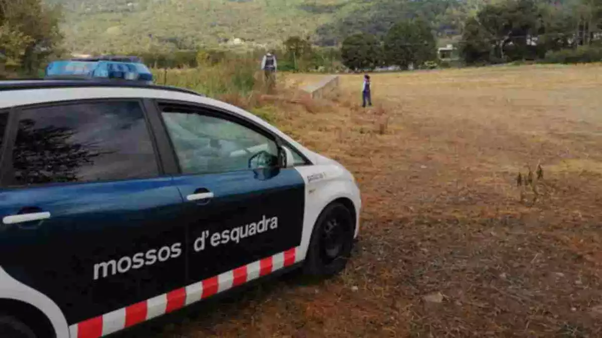 Un cotxe dels Mossos d'Esquadra i dos agents molt darrere a la cerca de l'home desaparegut