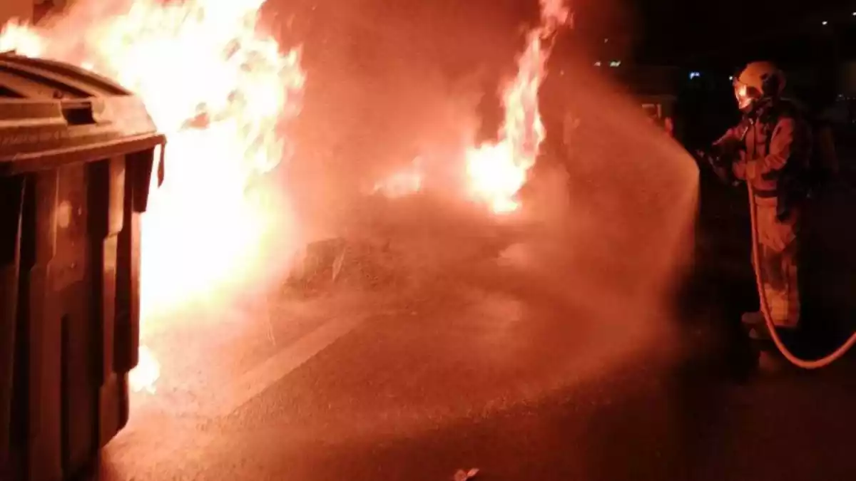 Els Bombers de la Generalitat apagant unes flames en uns contenidors a l'Avinguda President Companys de Reus