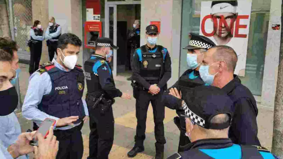 Agents de la Guàrdia Urbana i dels Mossos d'Esquadra davant l'entitat bancària assaltada a Lleida
