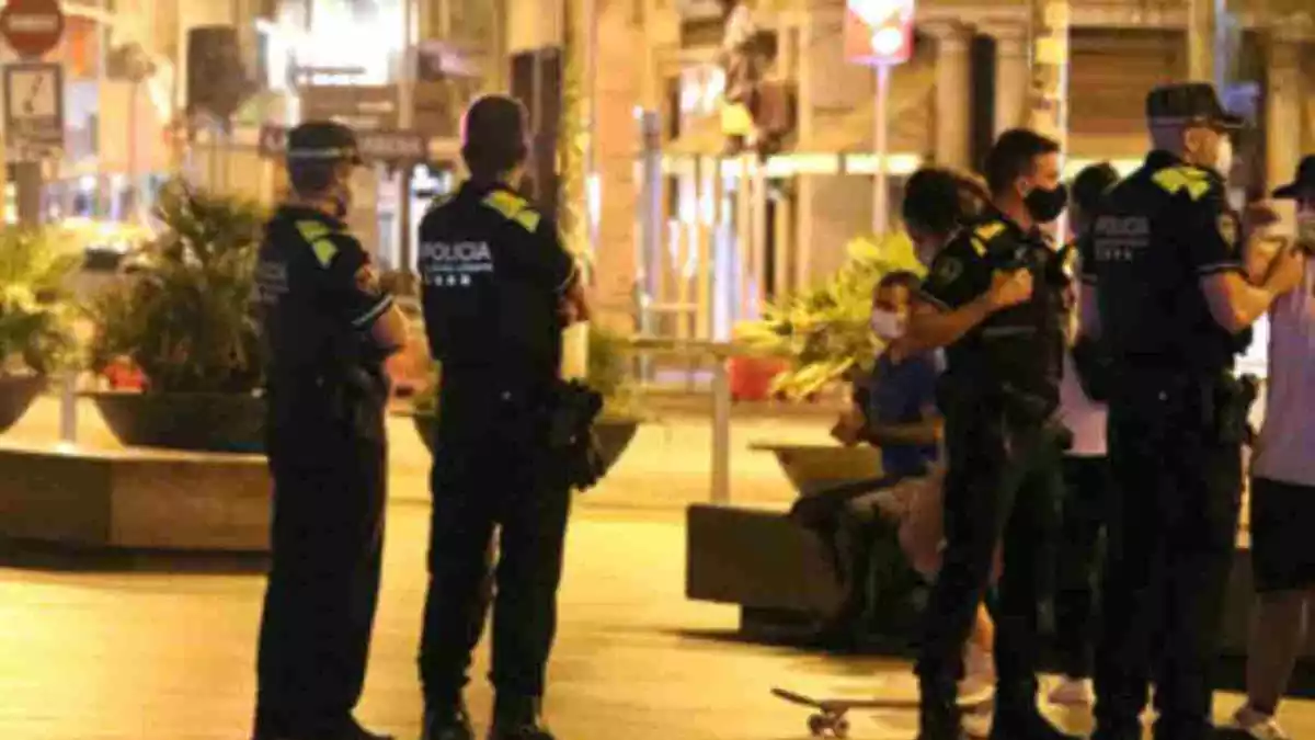 Diversos agents de la Guàrdia Urbana de Barcelona de nit aturant un 'botellón' a la ciutat