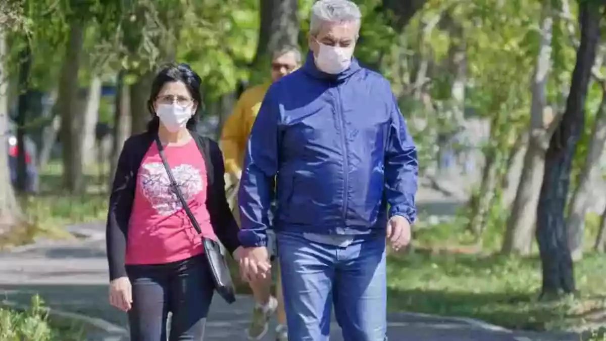 Una parella caminant pel carrer amb mascareta