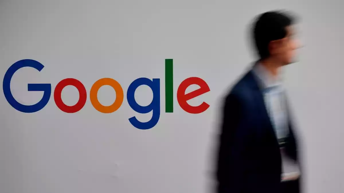 Un home passa per davant d'un logotip de Google