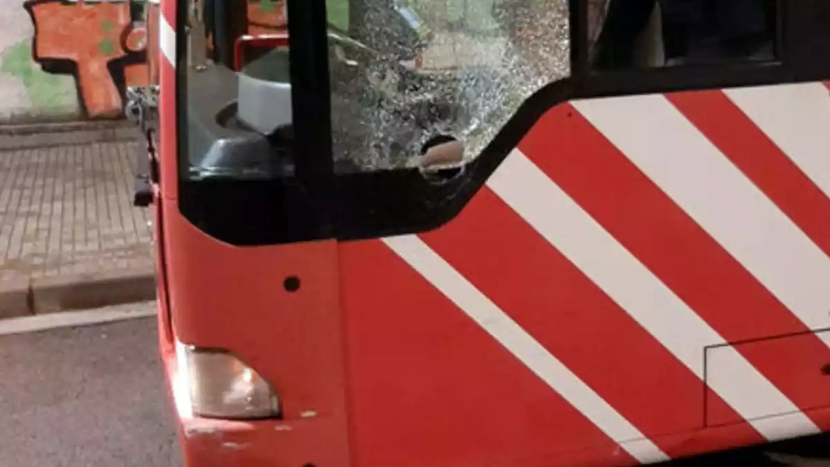Pla detall d'un autobús de l'EMT amb els vidres trencats
