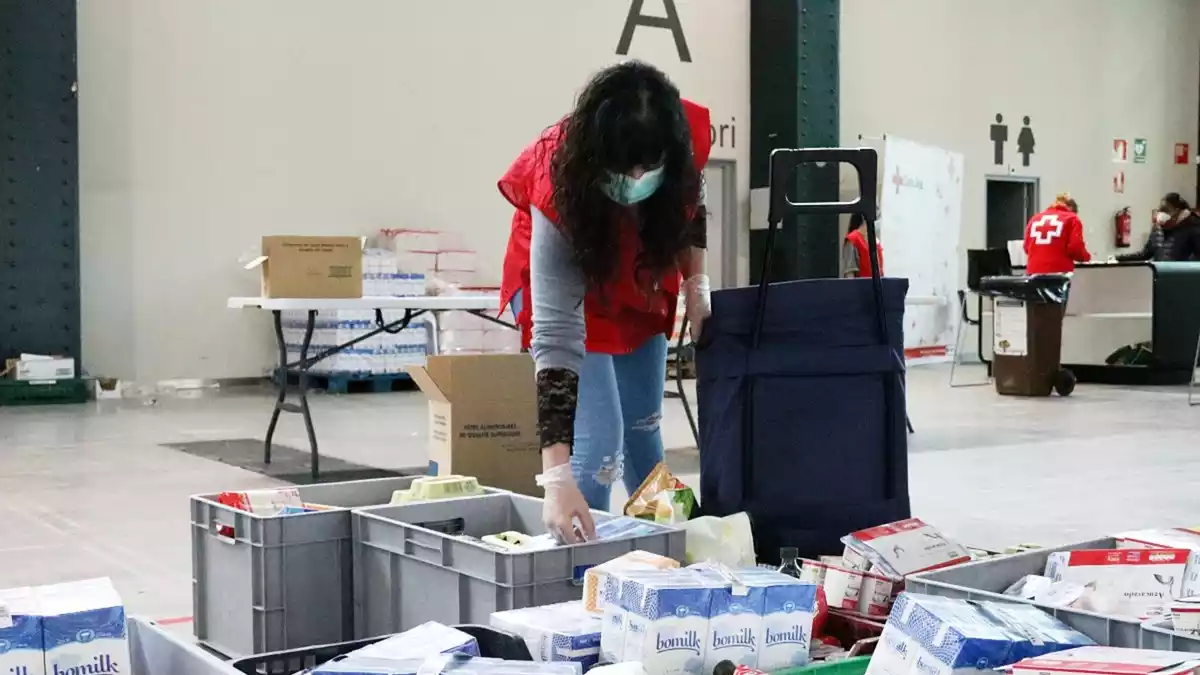 Imatge d'una voluntària de Creu Roja Sabadell preparant lots del Rebost Solidari el 23 de març de 2020