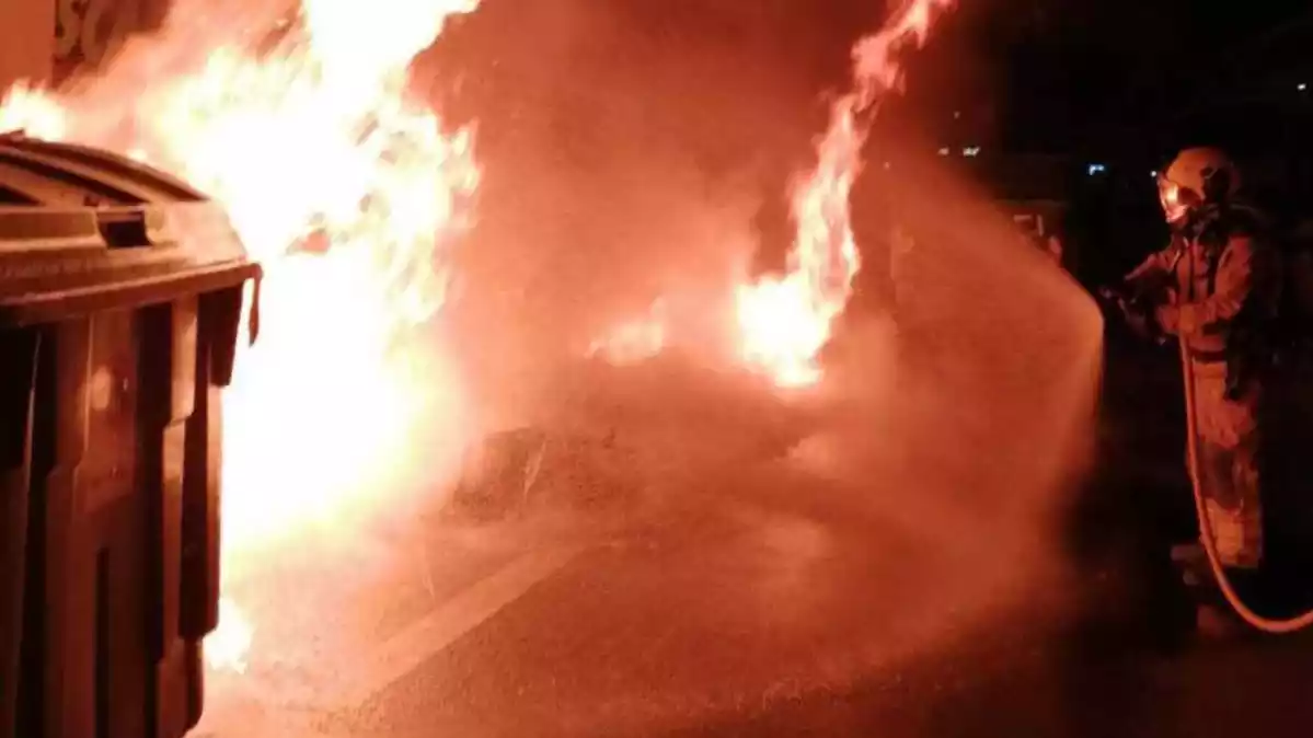 Els Bombers de la Generalitat apagant unes flames en uns contenidors a l'Avinguda President Companys de Reus