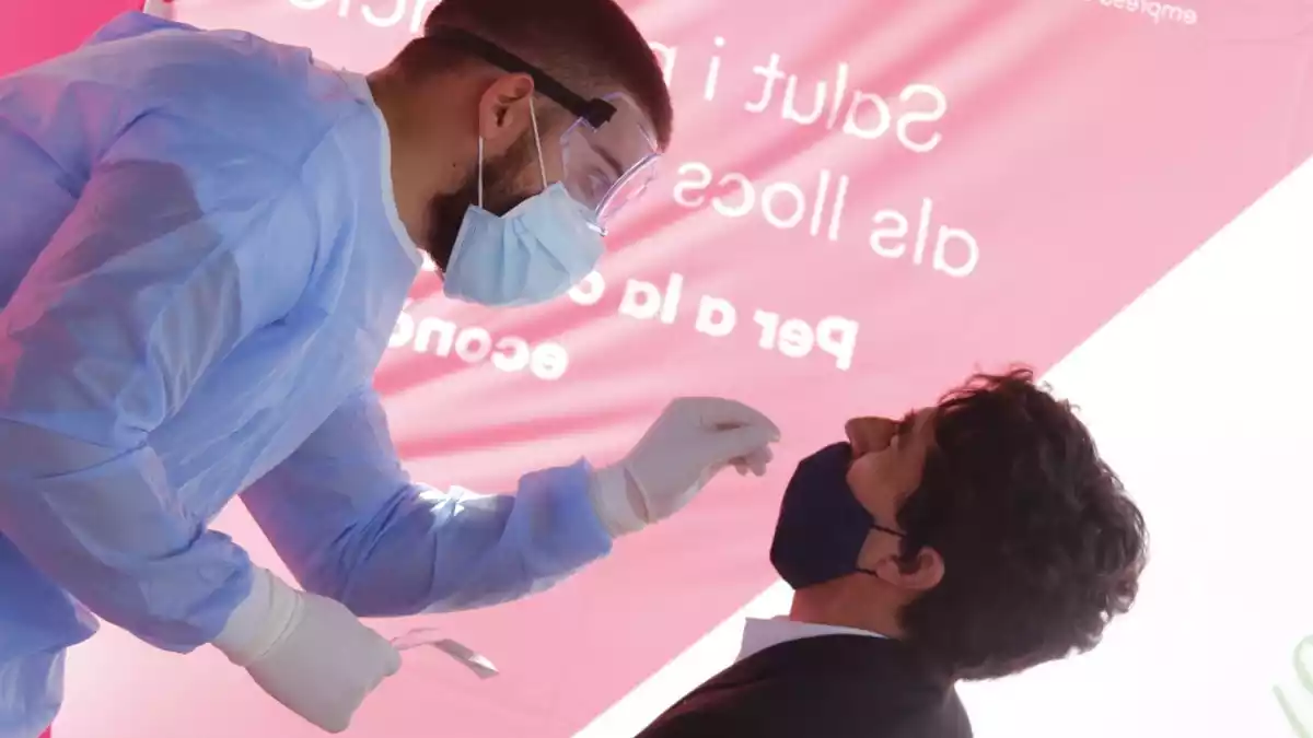 Personal sanitari pren mostres a un treballador del polígon de Sant Quirze del Vallès per fer un test d'antígen