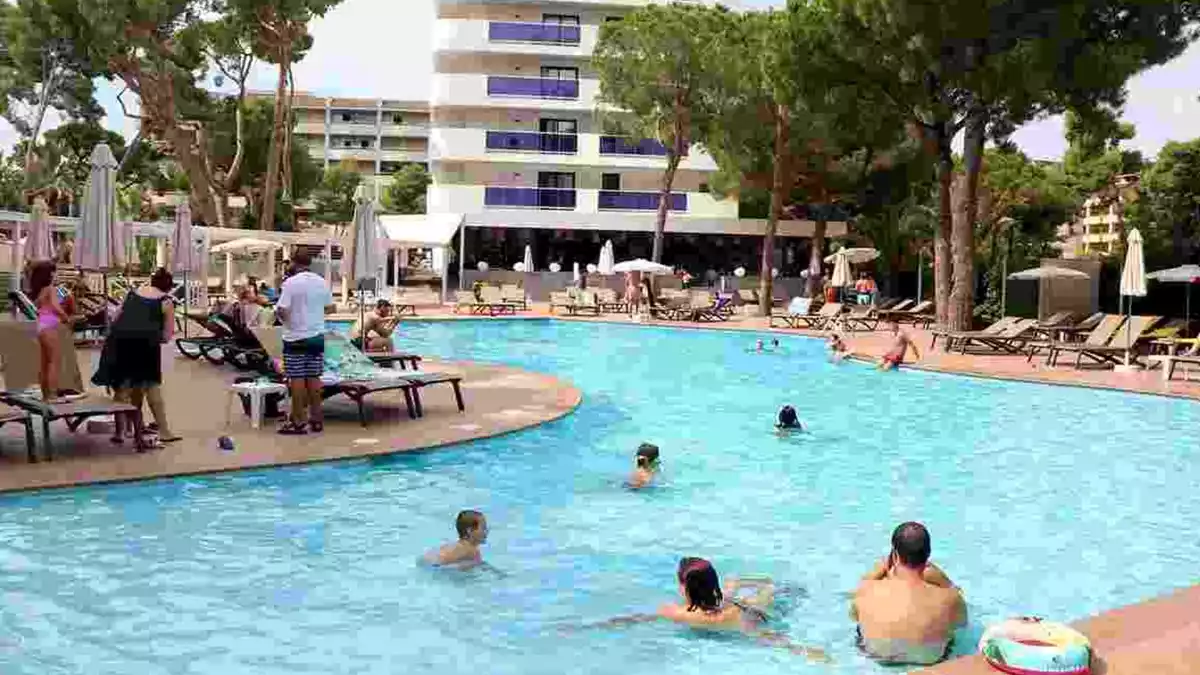 Pla general de turistes banyant-se i prenent el sol en una piscina de l'hotel Golden Port Salou & Spa,
