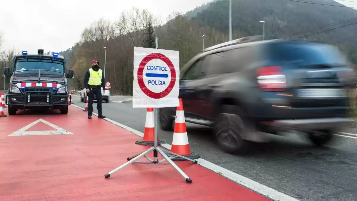 Un control dels Mossos d'Esquadra amb un agent aturat davant del seu vehicle i un cotxe circulant