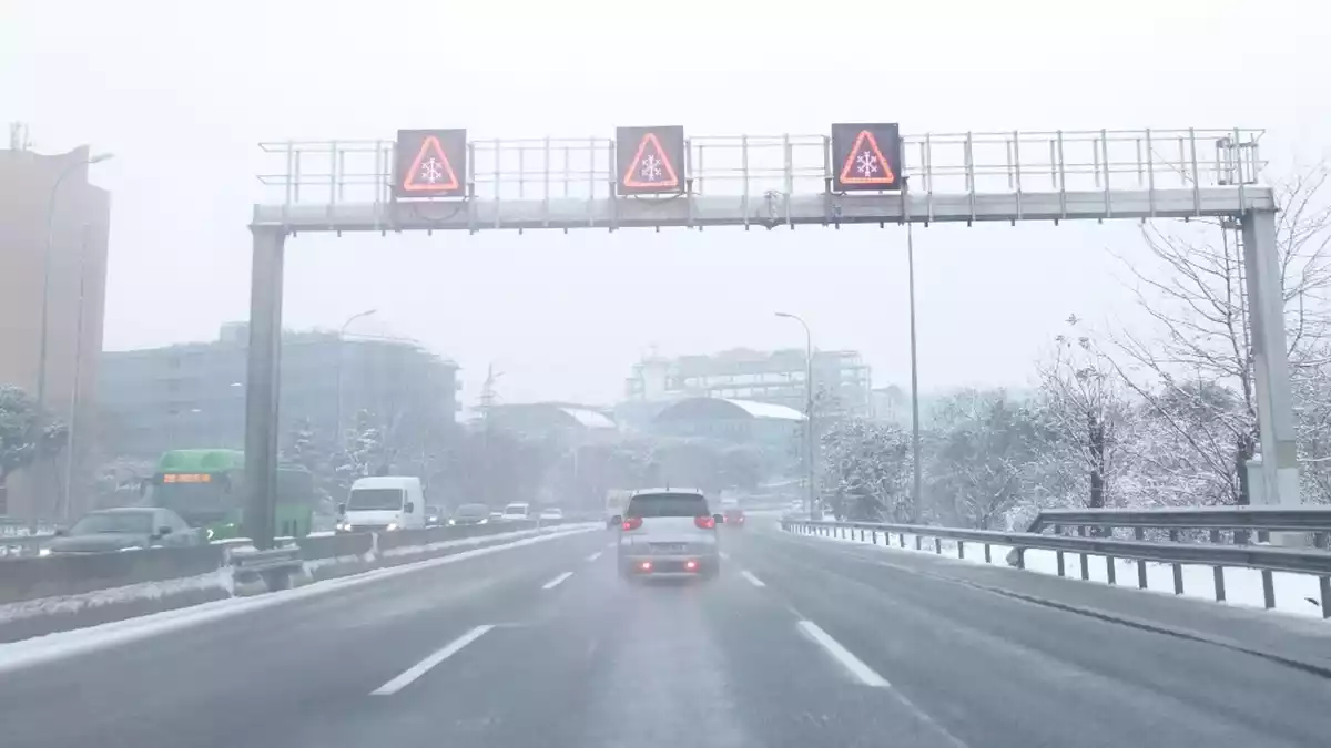 Un cotxe per una autopista completament buida a Madrid, a causa de la gran nevada