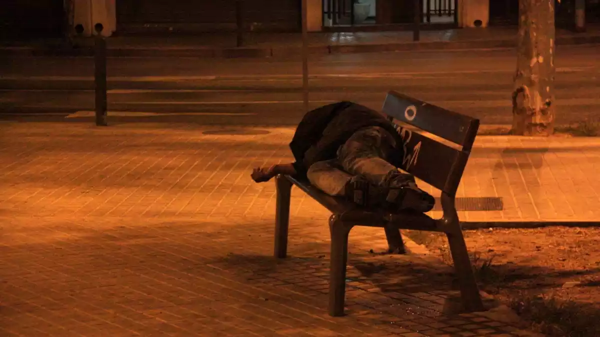 Un sense sostre dormint en un banc, a Badalona