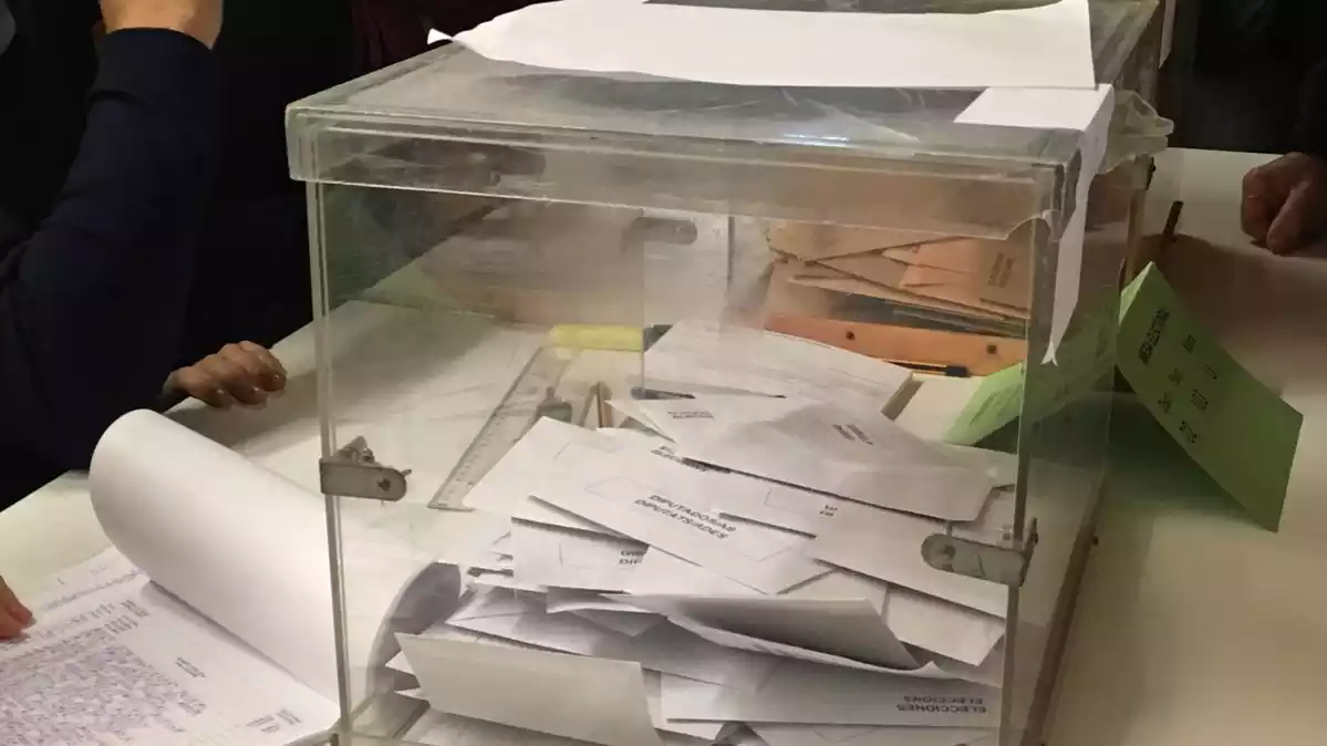 Imatge d'una urna, plena de vots, durant un procés electoral