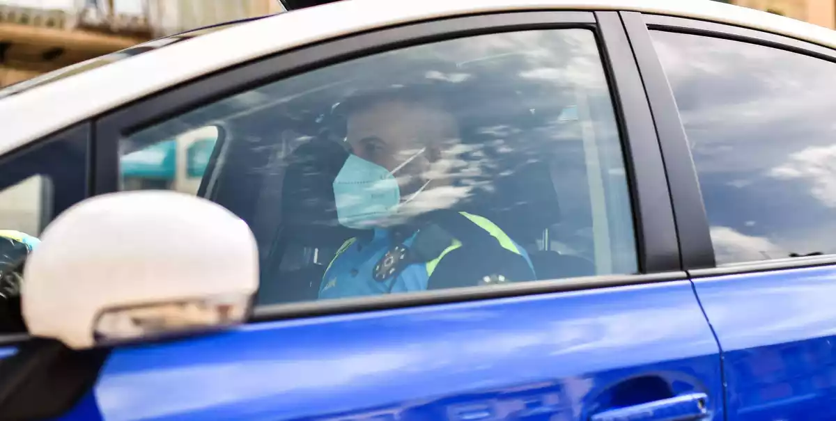 Un agent de la Guàrdia Urbana de Reus dins d'un vehicle policial, amb mascareta