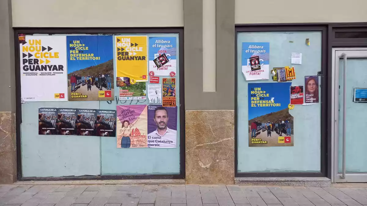 Imatge d'un local buit ple de cartells de les darreres eleccions al Parlament