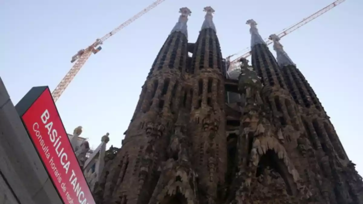 La Basílica de la Sagrada Família amb les obres de construcció i un cartell anunciant que està tancada