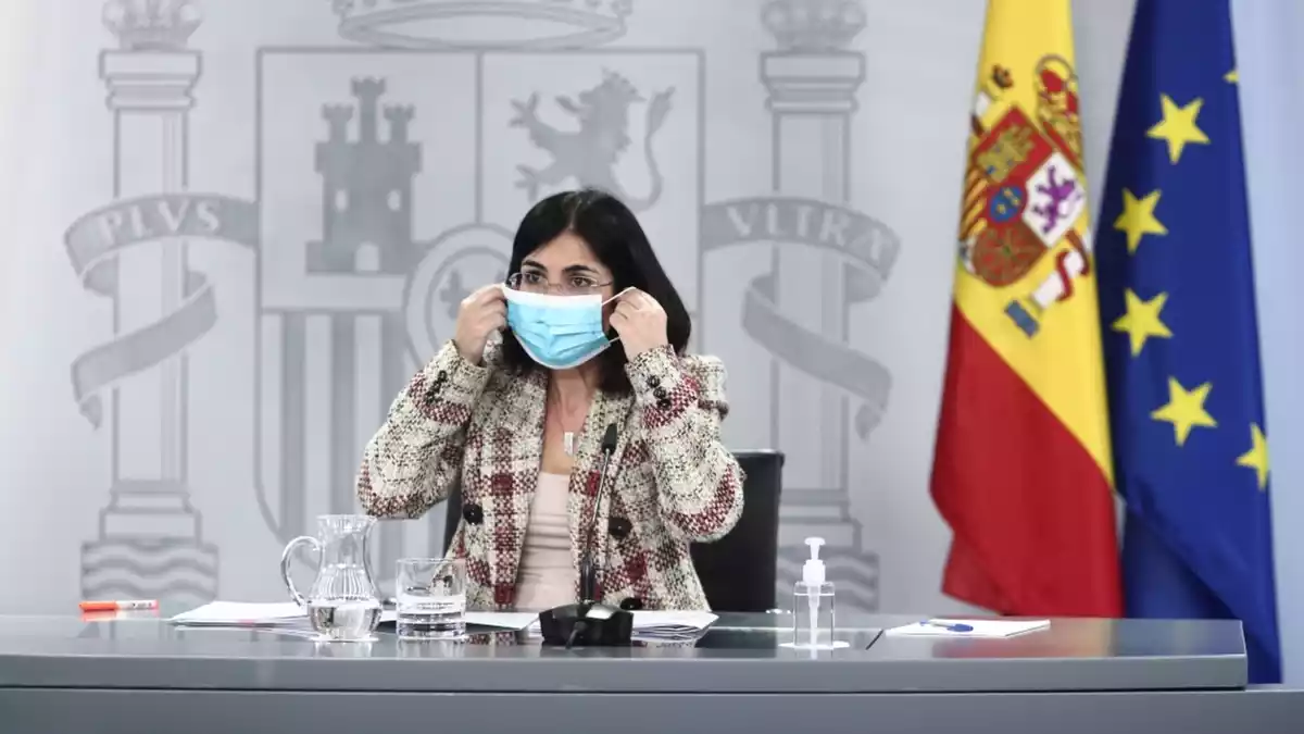 La ministra de Sanitat, Carolina Darias, posant-se la mascareta en una roda de premsa