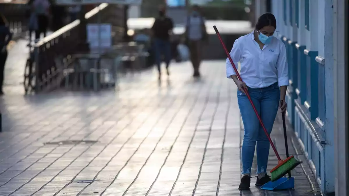 Una dona escombrant una terrassa buida durant les restriccions a Espanya