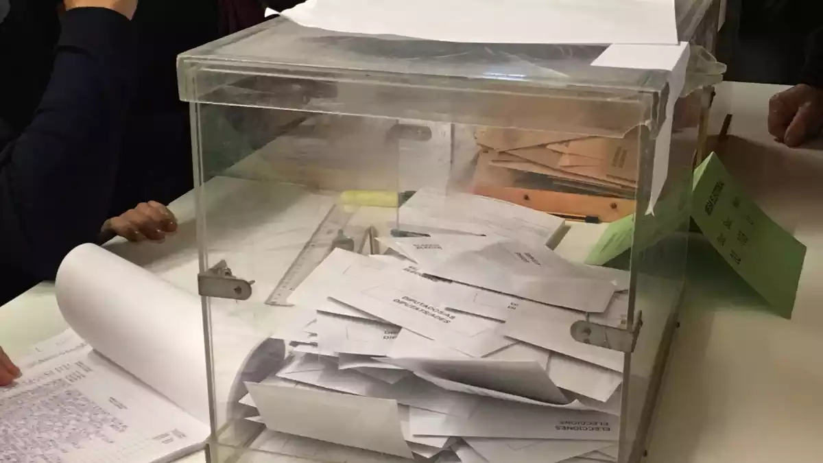 Imatge d'una urna, plena de vots, durant un procés electoral