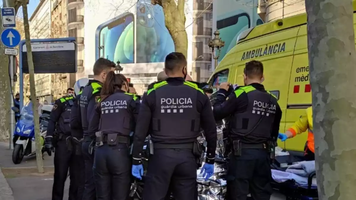 Agents de la Guàrdia Urbana de Barcelona i el SEM traslladant la mare i el nadó a l'hospital