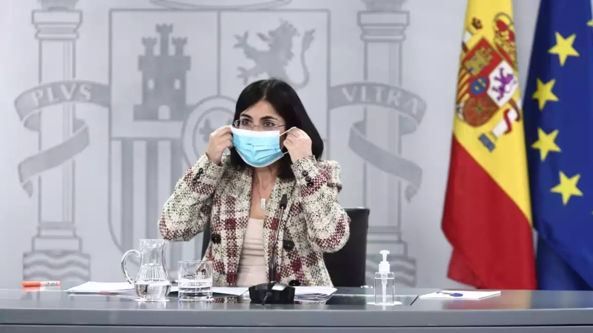 La ministra de Sanitat, Carolina Darias, posant-se la mascareta en una roda de premsa