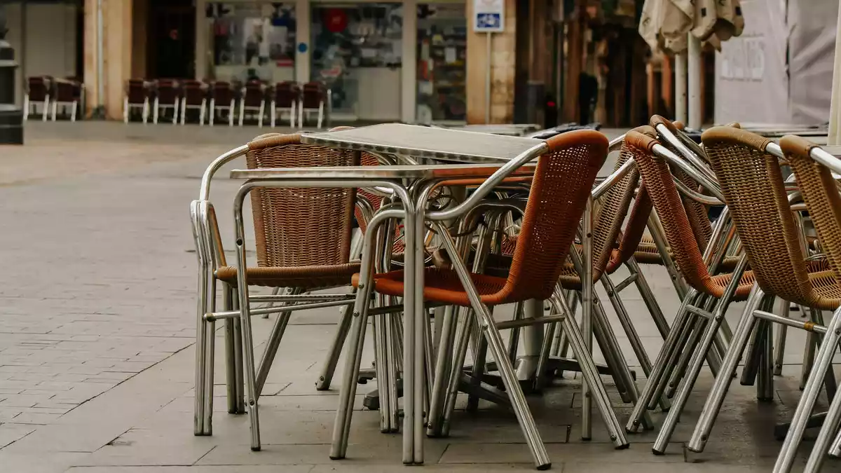 Taules i cadires d'una terrassa de bar buides