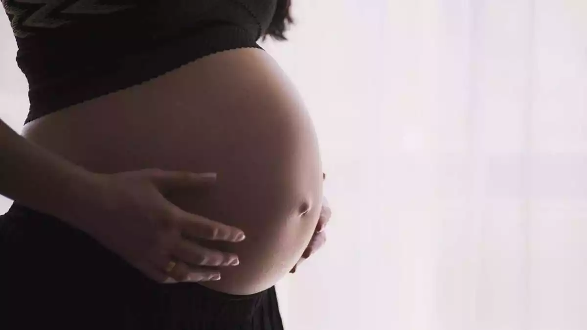 Una dona embarassada tocant-se la panxa amb les dos mans
