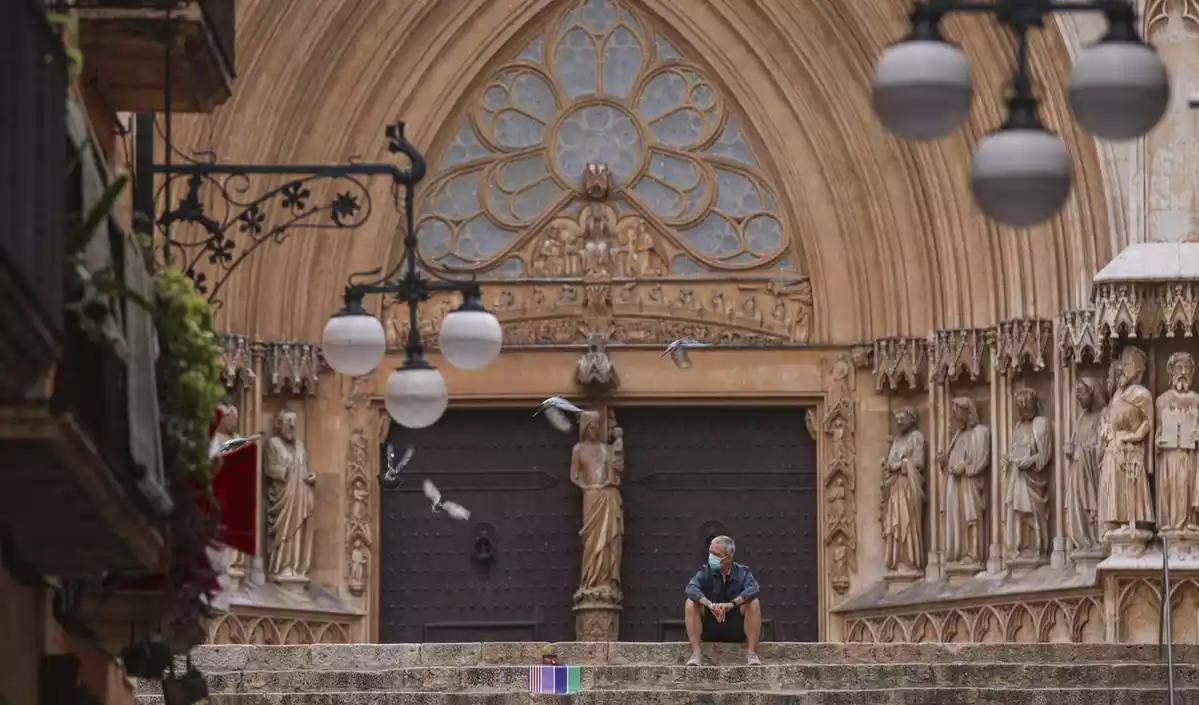 Home assegut davant de la Catedral de Tarragona.