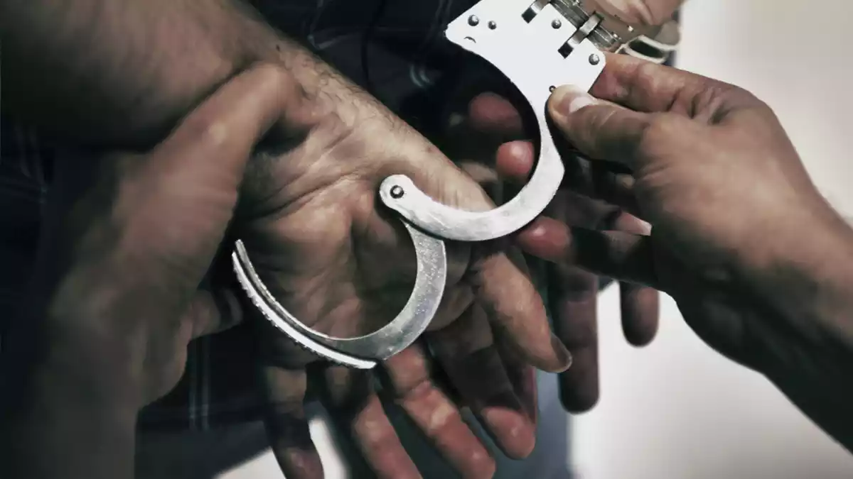 Un agent dels Mossos durant la detenció d'un sospitós amb les mans immobilitzades
