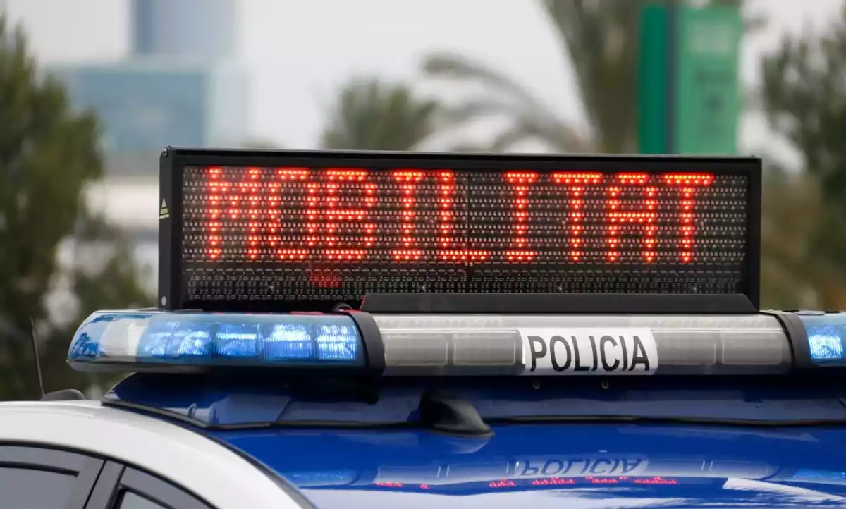 Un vehicle de policia amb un avís sobre la mobilitat restringida a Catalunya