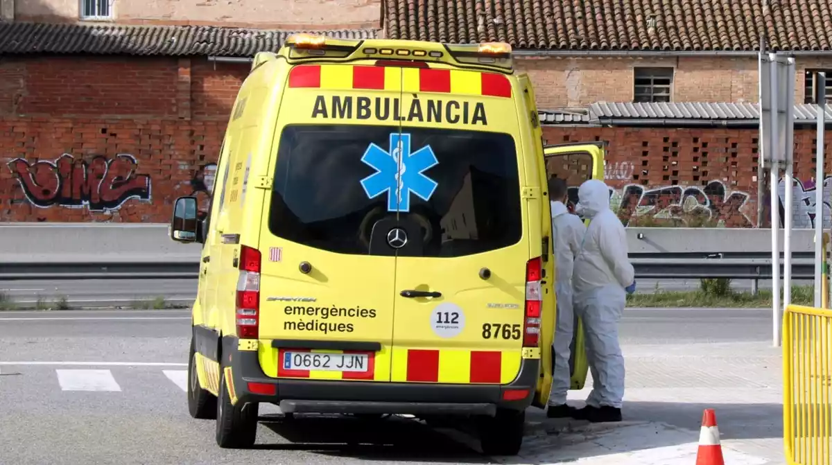 Una ambulància del SEM amb dos tècnics amb roba especial contra la Covid-19