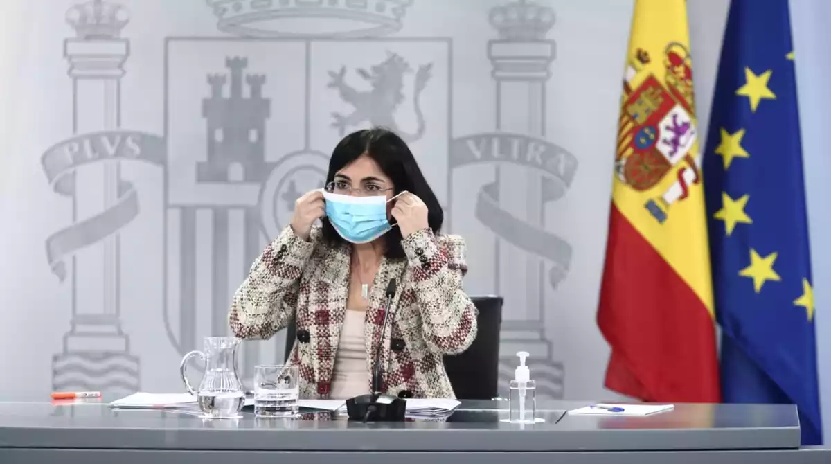 La ministra de Sanitat, Carolina Darias, posant-se la mascareta en una roda de premsa