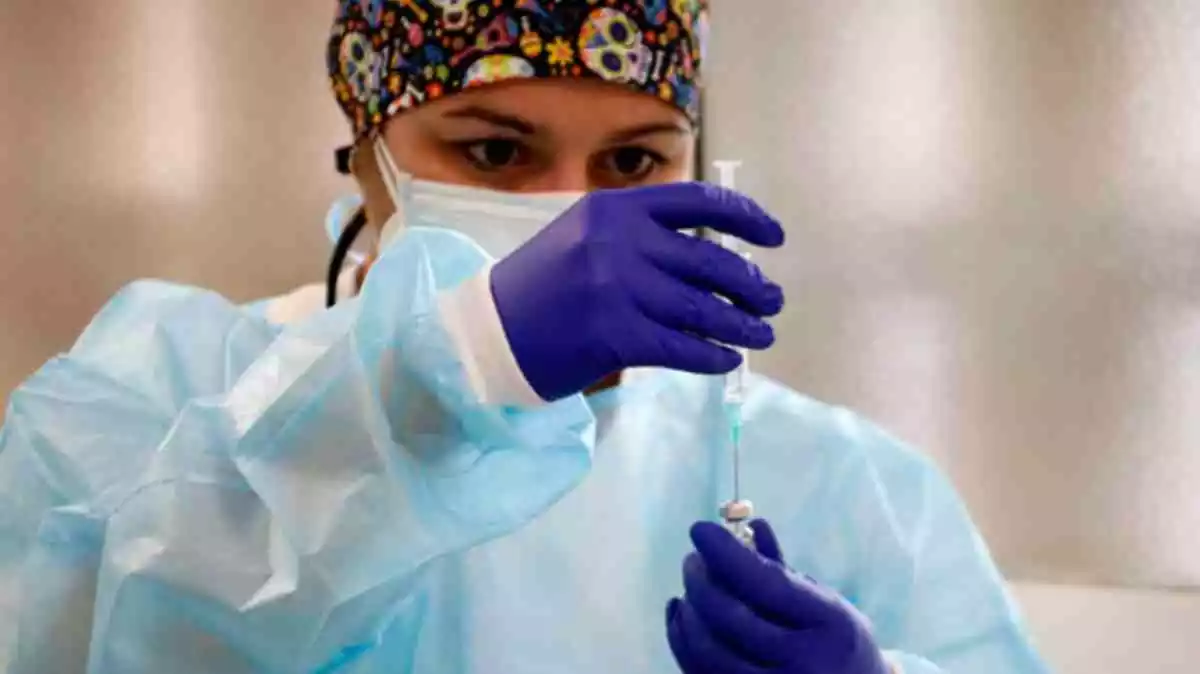 Pla mitjà on es pot veure una infermera preparant una dosi de la vacuna contra la covid-19, al Cap de Balàfia - Pardinyes