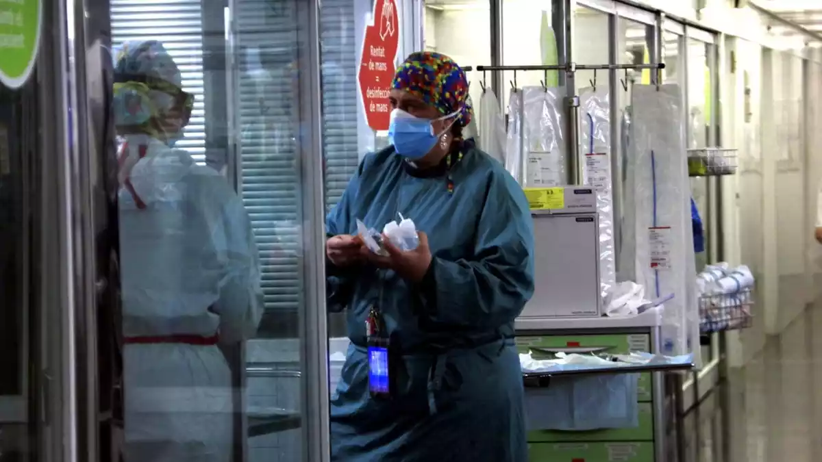 Sanitària portant material a una companya en una UCI de l'Hospital del Mar amb pacients Covid-19, en la tercera onada de la pandèmia del coronavirus