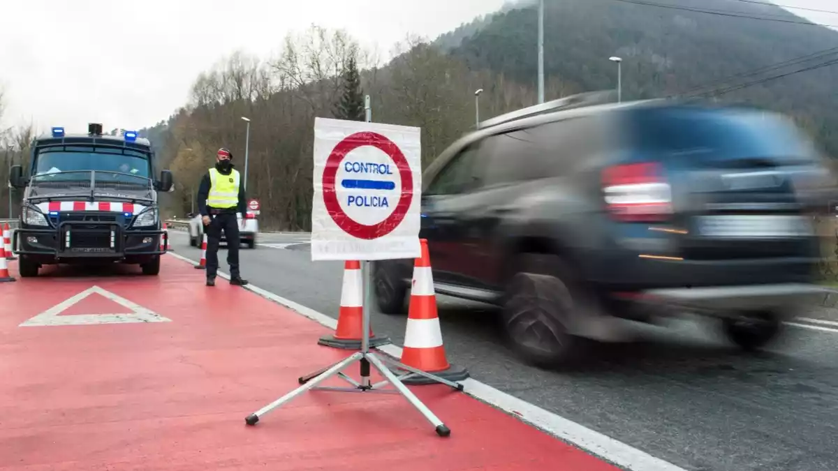 Un control dels Mossos d'Esquadra amb un agent aturat davant del seu vehicle i un cotxe circulant