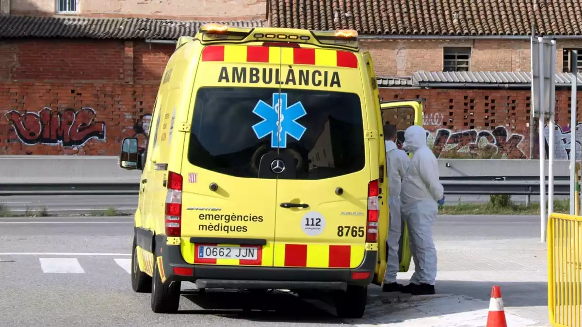 Una ambulància del SEM amb dos tècnics amb roba especial contra la Covid-19