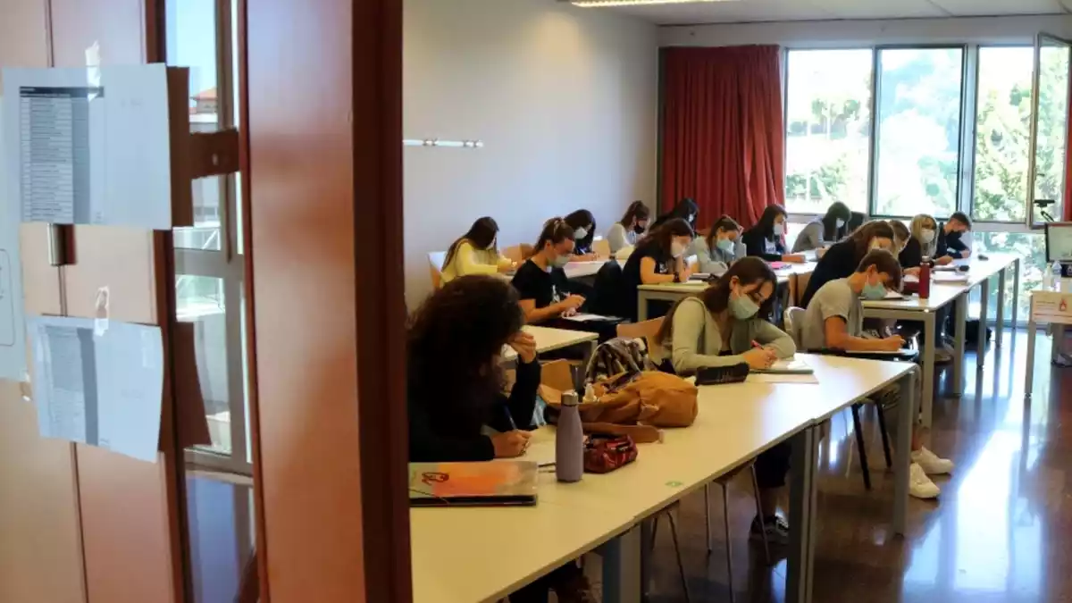 Pla obert d'una aula de la URV, vista des de fora, amb alumnes fent classe amb mascareta en el primer dia del curs 2020-2021