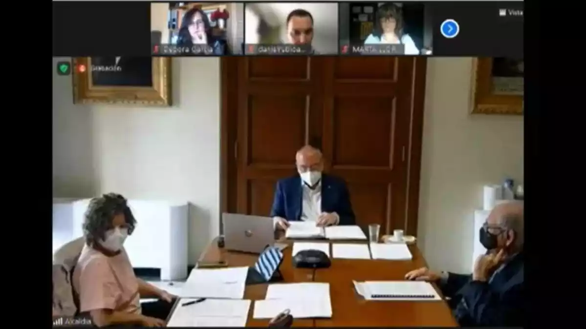 Imatge del ple telemàtic de Reus, amb Vilella, Pellicer i l'interventor muncicipal a l'Ajuntament i la resta de regidors per videoconferència