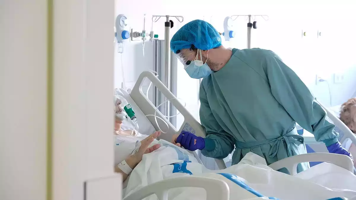 Un professional sanitari atén un pacient al nou espai polivalent de l'Hospital de Bellvitge el 26 de gener del 2021