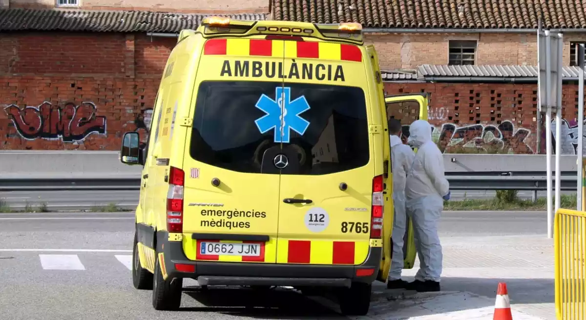 Una ambulància del SEM amb dos tècnics amb roba especial contra la Covid-19