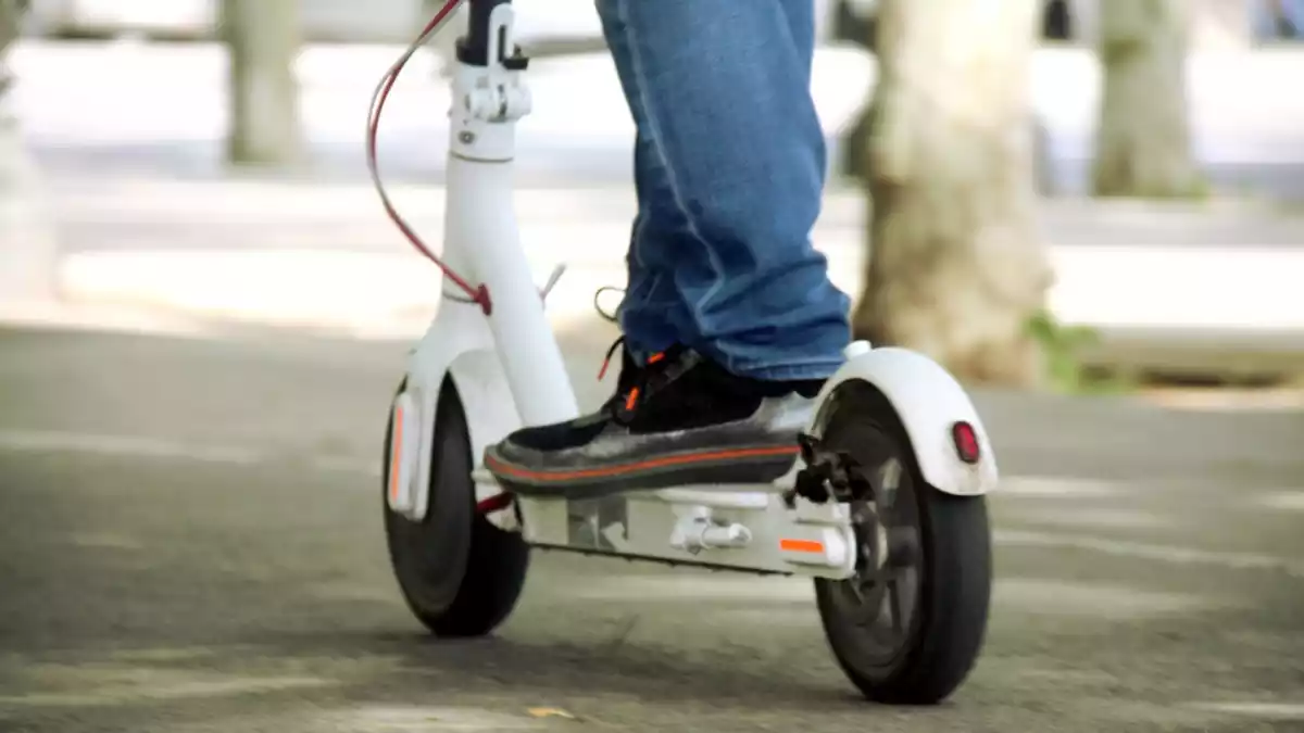 Una persona circulant amb un patinet elèctric.