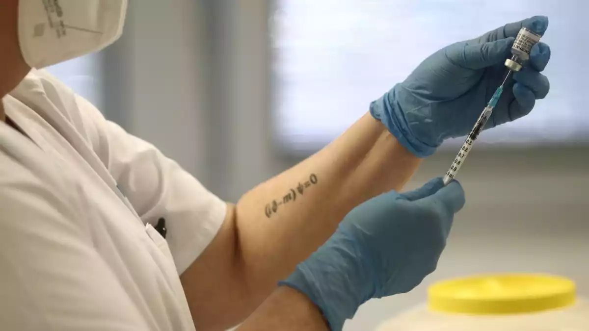 Una sanitària sosté una dosi de la vacuna de Pfizer abans d'administrar-la a un pacient