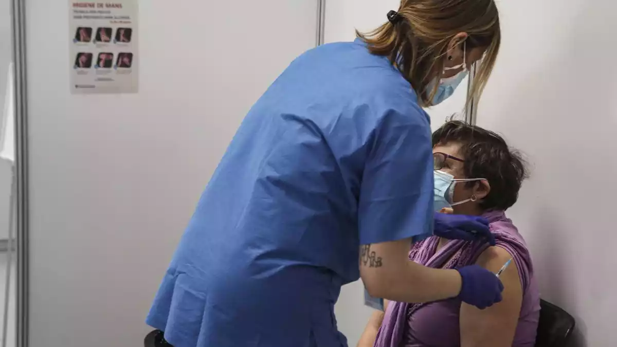 Una infermera administrant una vacuna a una senyora