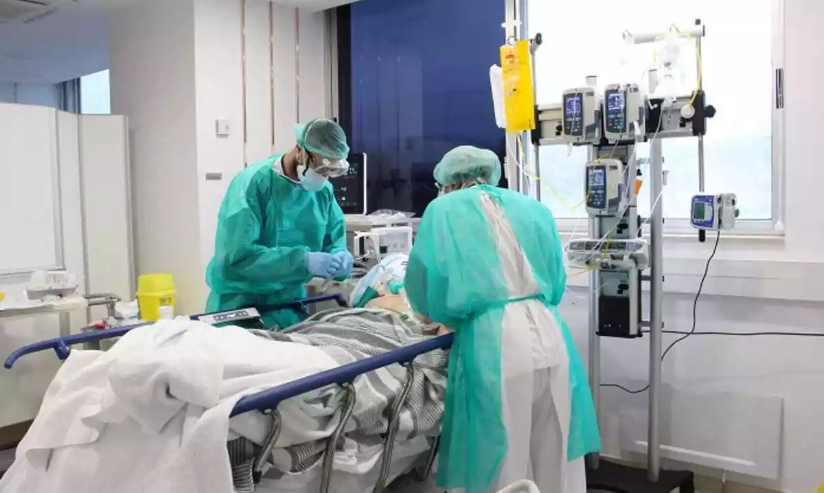 Two doctors or nurses treating a Covid-19 patient