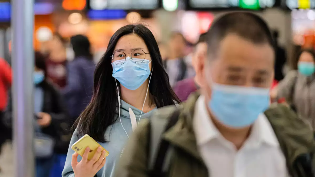 Los viajeros usan una máscara quirúrgica en la sala de embarque de la estación de West Kowloon Rail, Hong Kong (China).